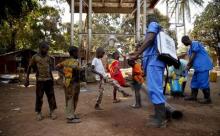 Children come forward to get their feet disinfected after a Red Cross worker explained that they are spraying bleach, and not spraying the village with the Ebola virus, in Forecariah, January 30, 2015, PHOTO BY REUTERS/Misha Hussain