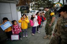 Bryan Waite, a U.S. navy officer based in JSA area for U.N. command, high-fives children at the Daesungdong Elementary School, a school inside the demilitarised zone separating the two Koreas, in Paju, South Korea. PHOTO BY REUTERS/Kim Hong-Ji
