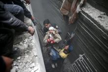 Syria Civil Defence members help an unconscious woman from a shelter in the besieged town of Douma, Eastern Ghouta, Damascus, Syria, February 22, 2018. PHOTO BY REUTERS/Bassam Khabieh