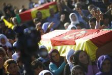 Turkish Kurdish women show the 'V' signs as they carry a coffin during the funeral of Kurdish fighters killed during clashes against Islamic State in the Syrian town of Kobani, at a cemetery in the southeastern town of Suruc, Sanliurfa province, October 24, 2014. PHOTO BY REUTERS/Kai Pfaffenbach