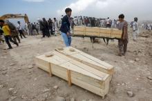 Afghan men carry empty coffins for the victims of yesterday's suicide attack in Kabul, Afghanistan, July 24, 2016. PHOTO BY REUTERS/Omar Sobha
