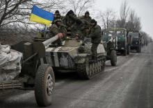 A convoy of Ukrainian armed forces including armoured personnel carriers, military vehicles and cannons prepare to move as they pull back from the Debaltseve region, in Paraskoviyvka, eastern Ukraine, February 26, 2015. PHOTO BY REUTERS/Gleb Garanich