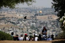 A crow flies past as Jewish school children gather at a look-out point on the Armon Hanatziv Promenade in Jerusalem, May 11, 2017. PHOTO BY REUTERS/Amir Cohen