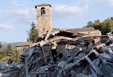 A rescue worker and a dog search among debris following an earthquake in Amatrice, central Italy, August 27, 2016. PHOTO BY REUTERS/Ciro De Luca