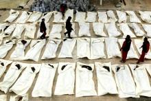 Workers document and count dead bodies, which according to the rebel fighters, were members of forces loyal to Syria's President Bashar al-Assad, before burying them in Aleppo, Syria, February 23, 2015. PHOTO BY REUTERS/Mahmoud Hebbo