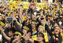 Demonstrators holding sunflowers shout slogans in front of the Presidential Office in Taipei