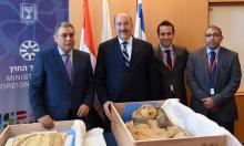 Egypt's Ambassador to Israel Hazem Khairat (L) and Dore Gold (2nd-L), director-general of Israel's foreign ministry, pose with Egyptian diplomats in front of ancient sarcophagi covers, which Israel handed back to Egypt, in Jerusalem, May 22, 2016. PHOTO BY REUTERS/Israeli Foreign Ministry