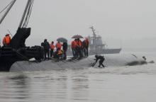 A diver (R) prepares to dive in the river to search for survivors after a ship sank at the Jianli section of the Yangtze River, Hubei province, China, June 2, 2015. PHOTO BY REUTERS/China Daily