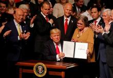 U.S. President Donald Trump holds a document he signed after announcing his Cuba policy at the Manuel Artime Theater in the Little Havana neighborhood in Miami, Florida, U.S., June 16, 2017. PHOTO BY REUTERS/Joe Skipper