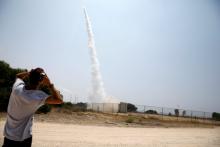An Israeli man looks on as an Iron Dome launcher fires an interceptor rocket in the southern Israeli city of Ashkelon, July 14, 2018. PHOTO BY REUTERS/Amir Cohen