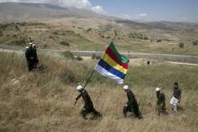Members of the Druze community walk next to the border fence between Syria and the Israeli-occupied Golan Heights, near the Druze village of Majdal Shams, as others watch the fighting in Syria's ongoing civil war, June 16, 2015. PHOTO BY REUTERS/Baz Ratner