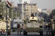 Egyptian army soldiers stand guard with their armoured personnel carriers (APC) in front of the El-Thadiya presidential palace