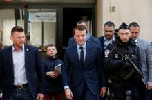 Emmanuel Macron (C), head of the political movement En Marche !, or Onwards !, and candidate for the 2017 French presidential election, leaves his home surrounded by policemen in Paris, France, April 24, 2017. PHOTO BY REUTERS/Benoit Tessier