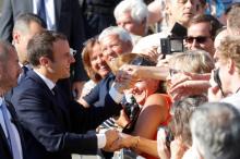 French President Emmanuel Macron shakes hands with supporters as he leaves city hall, after casting his ballot in the second round of the parliamentary election, in Le Touquet, France, June 18, 2017. PHOTO BY REUTERS/Philippe Wojazer