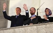 Turkish Prime Minister Tayyip Erdogan (L), accompanied by his son Bilal and daughter Sumeyye, greets his supporters at the AK Party headquarters in Ankara