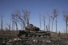 A fighter with the separatist self-proclaimed Donetsk People's Republic army looks at a destroyed Ukrainian army tank near the town of Debaltseve, February 22, 2015. PHOTO BY REUTERS/Baz Ratner