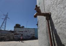 Residents walk past a leaking communal tap in Khayelitsha township, near Cape Town, South Africa, December 12, 2017. PHOTO BY REUTERS/Mike Hutchings