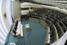Members of the Federation Council, Russia's upper house of parliament, stand before a session in Moscow