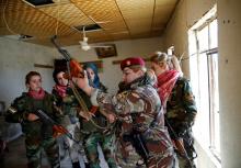 Iraqi Kurdish female fighter Haseba Nauzad (2nd R), 24, holds her weapon as she is surrounded by comrades at a site during a deployment near the frontline of the fight against Islamic State militants in Nawaran near Mosul, Iraq, April 20, 2016. PHOTO BY REUTERS/Ahmed Jadallah