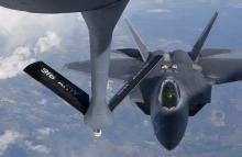 A pilot looks up from a U.S. F-22 Raptor fighter at a fuel boom as it prepares to refuel in mid-air with a KC-135 plane over European airspace during a flight to Britain from Mihail Kogalniceanu air base in Romania, April 25, 2016. PHOTO BY REUTERS/Toby Melville