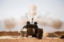 A Hezbollah fighter reacts as he fires a weapon in Western Qalamoun, Syria, August 23, 2017. PHOTO BY REUTERS/Omar Sanadiki