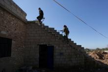 Rebel fighters carry their weapons as they climb a staircase on the outskirts of Al-Bab town in Syria, January 22, 2017. PHOTO BY REUTERS/Khalil Ashawi