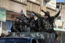 Fighters of the Kurdish People's Protection Units (YPG) carry their weapons along a street in the Syrian Kurdish city of Qamishli, in celebration after it was reported that Kurdish forces took control of the Syrian town of Tel Hamis, February 27, 2015. PHOTO BY REUTERS/Rodi Said