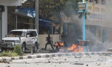 A Somali military officer carries his gun as he secures the scene of a suicide car bombing near Somalia's presidential palace in Mogadishu, Somalia, July 7, 2018. PHOTO BY REUTERS/Feisal Omar