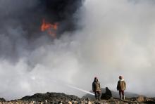 Oil workers work in front of oilfields burned by Islamic State fighters in Qayyara, south of Mosul, Iraq November 23, 2016. PHOTO BY REUTERS/Goran Tomasevic