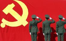 Paramilitary policemen hold their fists in front of a flag of Communist Party of China as they attend an oath-taking rally to ensure the safety of the upcoming 18th National Congress of the Communist Party of China (CPC), at a military base in Hangzhou, Zhejiang province, November 5, 2012. PHOTO BY REUTERS/China Daily