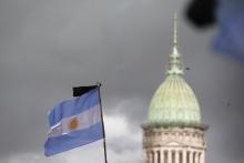 A black ribbon is seen on a national flag with the National Congress building in the background during a silent march to honour late state investigator Alberto Nisman in Buenos Aires, February 18, 2015. PHOTO BY REUTERS/Enrique Marcarian
