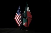 A staff member removes the Iranian flag from the stage after a group picture with foreign ministers and representatives of the U.S., Iran, China, Russia, Britain, Germany, France and the European Union during the Iran nuclear talks at the Vienna International Center in Vienna, Austria, July 14, 2015. PHOTO BY REUTERS/Carlos Barria