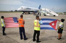 Ground crew hold U.S. and Cuban flags near a recently landed JetBlue aeroplane, the first commercial scheduled flight between the United States and Cuba in more than 50 years, at the Abel Santamaria International Airport in Santa Clara, Cuba, August 31, 2016. PHOTO BY REUTERS/Alexandre Meneghini