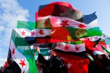 People wave Turkish and Free Syrian Army flags during a gathering before the departure of a Syria-bound aid convoy, carrying humanitarian supplies, in Istanbul, Turkey. PHOTO BY REUTERS/Murad Sezer