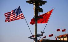 U.S. (L) and Chinese national flags flutter on a light post at the Tiananmen Square ahead of a welcoming ceremony for U.S. President Barack Obama, in Beijing, November 12, 2014. PHOTO BY REUTERS/Petar Kujundzic