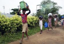 Residents flee with their belongings after clashes between forces loyal to former president Laurent Gbagbo and those supporting Ivory Coast's new President Alassane Ouattara in Cocody, Abidjan April 13, 2011. REUTERS/Thierry Gouegnon