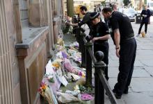 Police officers look at flowers and messages left for the victims of the Manchester Arena attack, in central Manchester, Britain, May 23, 2017. PHOTO BY REUTERS/Darren Staples