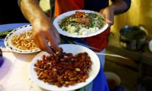 Finishing touches are made to Syrian dinners before being handed out, as refugees celebrate Eid al-Adha with Austrian villagers in the hall of Schloss Koenigshof, an ancient Habsburg castle in Bruckneudorf, Austria, September 24, 2015. PHOTO BY REUTERS/Leonhard Foeger