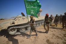 Shi'ite Popular Mobilization Forces (PMF) members and an Iraqi army military vehicle are seen on the outskirts of Tal Afar, Iraq, August 22, 2017. PHOTO BY REUTERS/Stringer