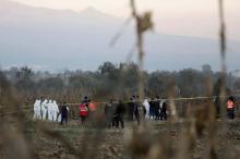 Forensic technicians and rescue personnel stand at the scene where the helicopter transporting Martha Erika Alonso, governor of the state of Puebla, and his husband Senator Rafel Moreno Valle crashed, in Coronango, Puebla Mexico, December 24, 2018. PHOTO BY REUTERS/Imelda Medina