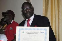 Former soccer star George Weah holds up a certificate of election after being elected senator in Monrovia, January 3, 2015. PHOTO BY REUTERS/James Giahyue