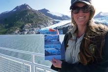 Chugach National Forest ranger Megan Parsley holds photos showing this summer's ice loss at the face of Portage Glacier, Alaska, U.S., August 17, 2019. PHOTO BY REUTERS/Yereth Rosen