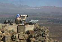 A Canadian member of the United Nations Disengagement Observer Force (UNDOF) looks through binoculars at Mount Bental, an observation post in the Israeli occupied Golan Heights near the ceasefire line between Israel and Syria, August 21, 2015. PHOTO BY REUTERS/Baz Ratner