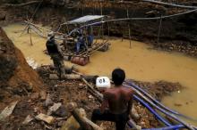An Yanomami indian (R) stands near an illegal gold mine during Brazil's environmental agency operation against illegal gold mining on indigenous land, in the heart of the Amazon rainforest, in Roraima state, Brazil, April 17, 2016. PHOTO BY REUTERS/Bruno Kelly