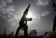 A Houthi follower rises a weapon as he attends a rally marking one year of Saudi-led air strikes, in Yemen's capital Sanaa, March 26, 2016. PHOTO BY REUTERS/Mohamed al-Sayaghi