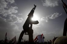 A Houthi follower rises a weapon as he attends a rally marking one year of Saudi-led air strikes, in Yemen's capital Sanaa, March 26, 2016. PHOTO BY REUTERS/Mohamed al-Sayaghi