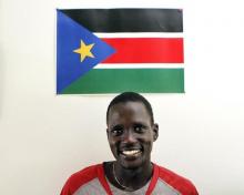 Guor Marial, 28, smiles in his apartment under a South Sudan flag in Flagstaff, Arizona July 21, 2012. PHOTO BY REUTERS/Darryl Webb