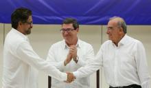 Colombia's FARC lead negotiator Ivan Marquez (L) and Colombia's lead government negotiator Humberto de la Calle (R) shake hands while Cuba's Foreign Minister Bruno Rodriguez looks on, after signing a final peace deal in Havana, Cuba, August 24, 2016. PHOTO BY REUTERS/Alexandre Meneghini