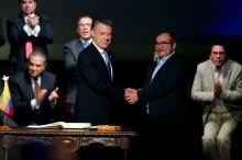 Colombia's President Juan Manuel Santos and Marxist FARC rebel leader Rodrigo Londono, known as Timochenko, shake hands after signing a peace accord in Bogota, Colombia, November 24, 2016. PHOTO BY REUTERS/Jaime Saldarriaga