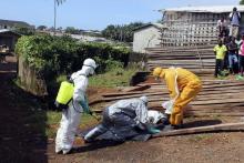 Health workers remove the body a woman who died from the Ebola virus in the Aberdeen district of Freetown, Sierra Leone, October 14, 2014. PHOTO BY REUTERS/Josephus Olu-Mammah